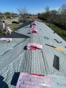 Stripped asphalt shingle roof with materials on top